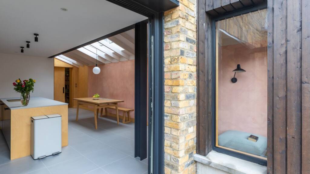 View of a black-framed window box looking into the kitchen through bi-fold doors.