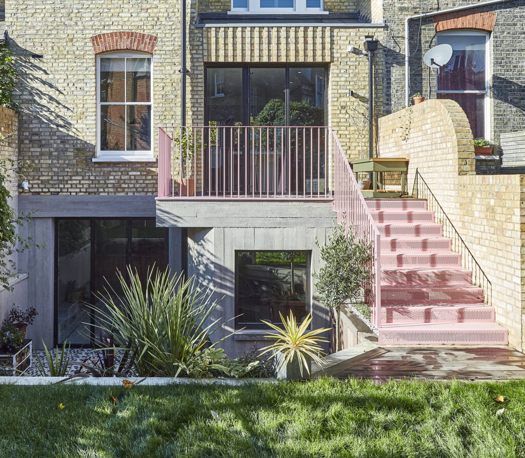 Pink sculptural staircase in a calm, light-filled Islington townhouse with layered architectural detailing.