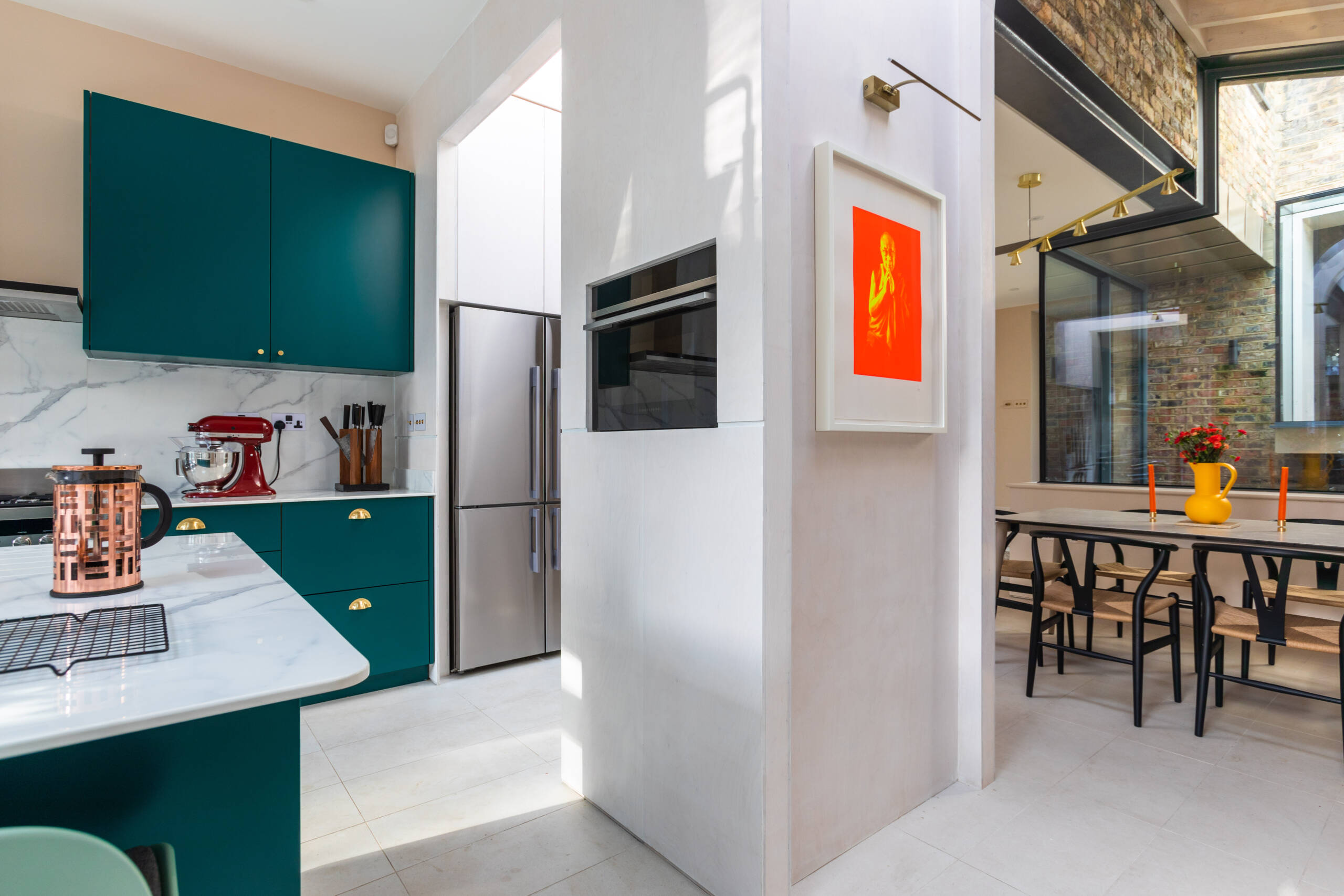 Bespoke teal green and gold kitchen with marble worktop, roof lanterns, and indoor courtyard in Southwark rear extension